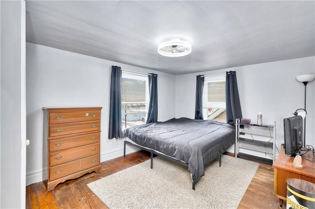 821 Vogan Street New Castle, PA 16101 - Photo 21 of 33 a bedroom with a bed and wooden floor