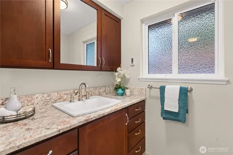 a bathroom with a granite countertop sink and a mirror