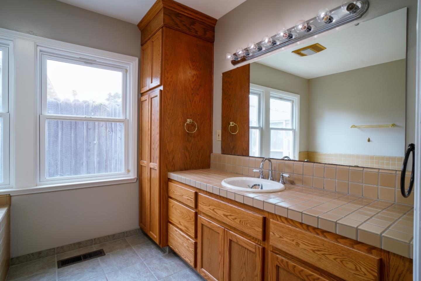 351 Lorimer Street Salinas, CA 93901 - Photo 15 of 37 a bathroom with a granite countertop sink and a mirror
