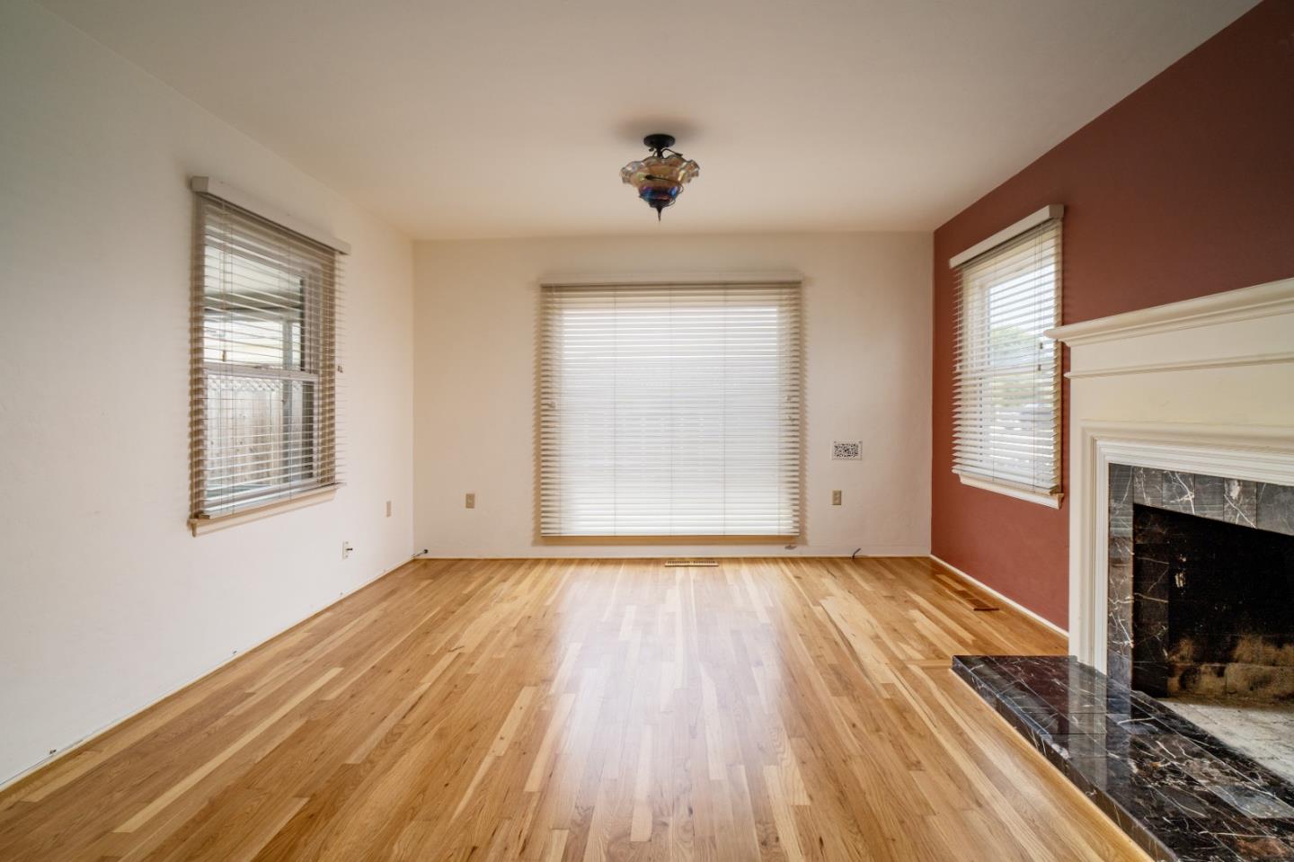 351 Lorimer Street Salinas, CA 93901 - Photo 5 of 37 a view of an empty room with wooden floor fireplace and a window