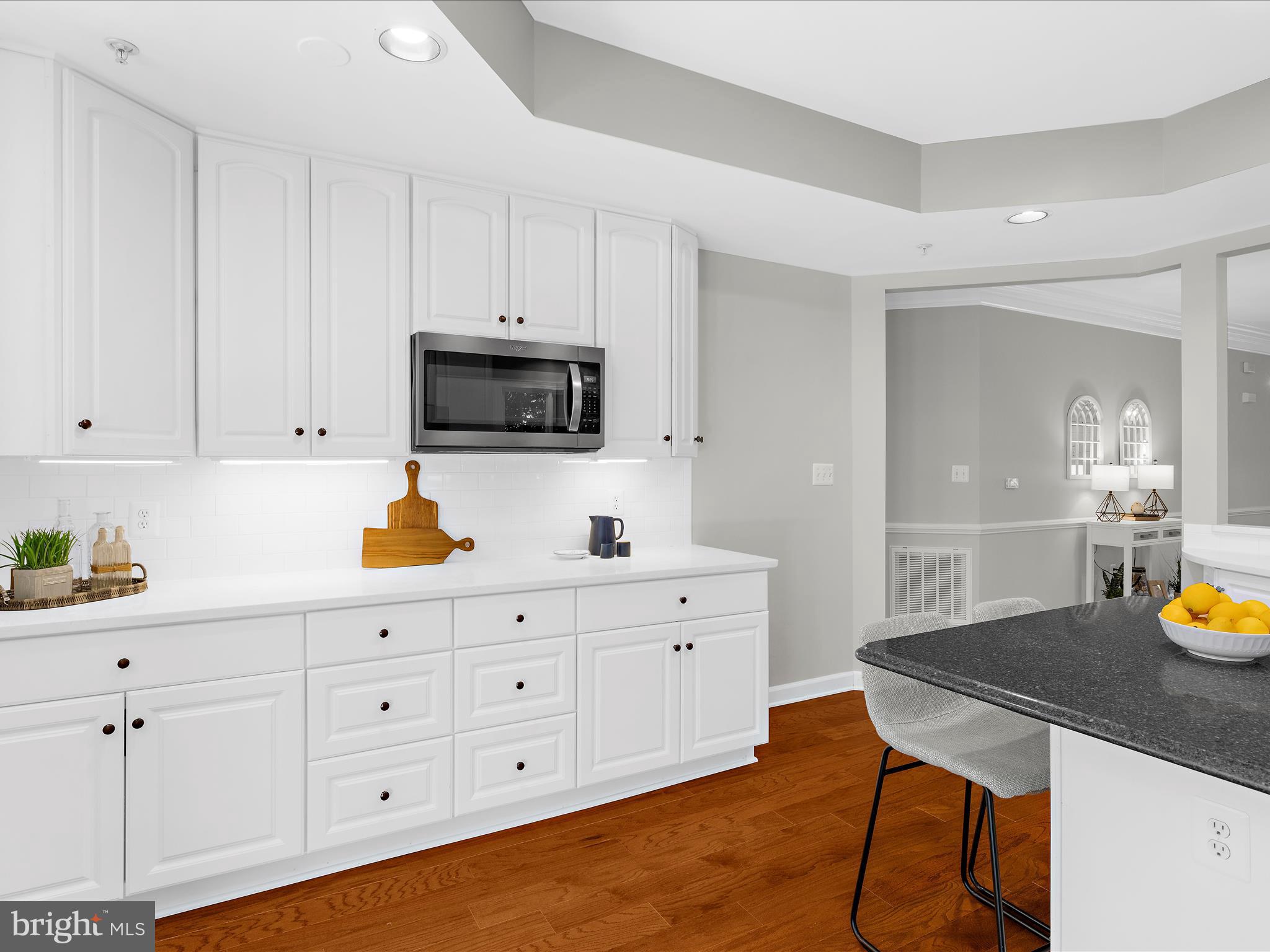 301 Colony Point Place Edgewater, MD 21037 - Photo 17 of 45 a kitchen with a sink a stove and white cabinets with wooden floor