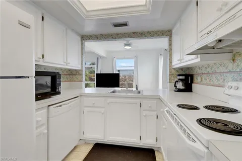 a kitchen with a sink and white cabinets