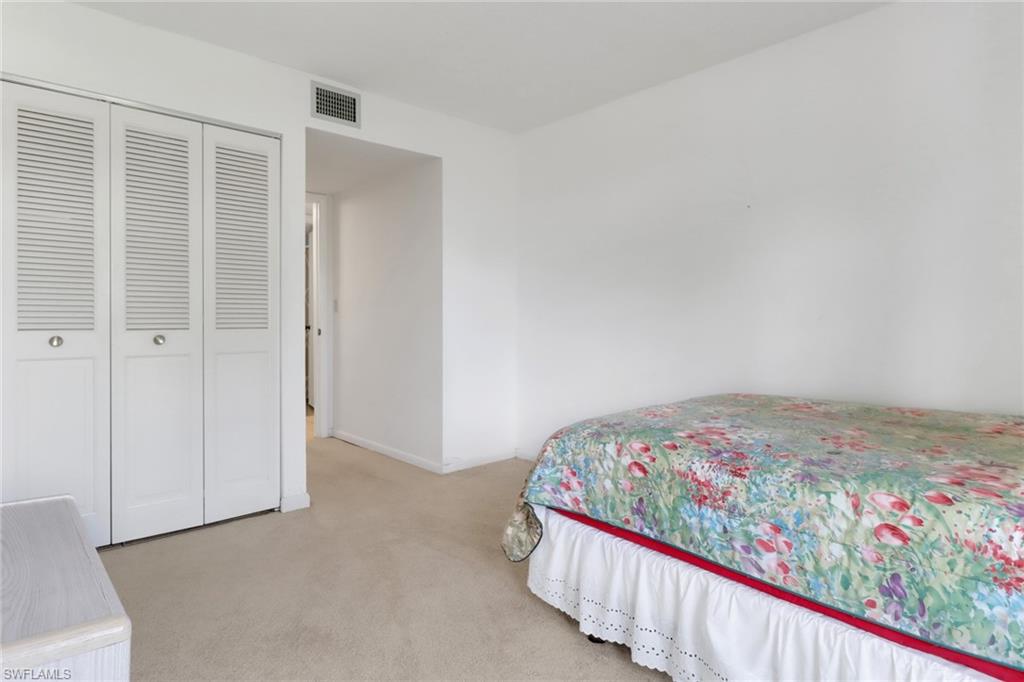 7077 Quail Run Court East, Unit A 15 Fort Myers, FL 33908 - Photo 23 of 43 a bedroom with a bed and a painting on the wall
