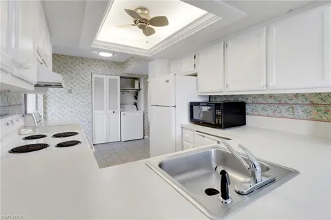 a kitchen with stainless steel appliances granite countertop a sink and a refrigerator