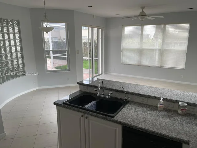 a kitchen with granite countertop a refrigerator and a sink
