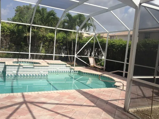 a view of a backyard with floor to ceiling window and wooden fence