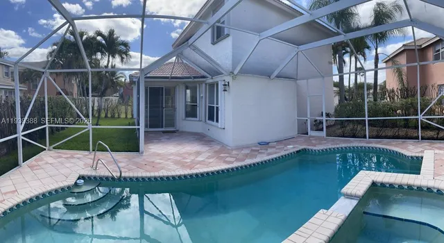 a view of a backyard with couches chair and floor to ceiling window