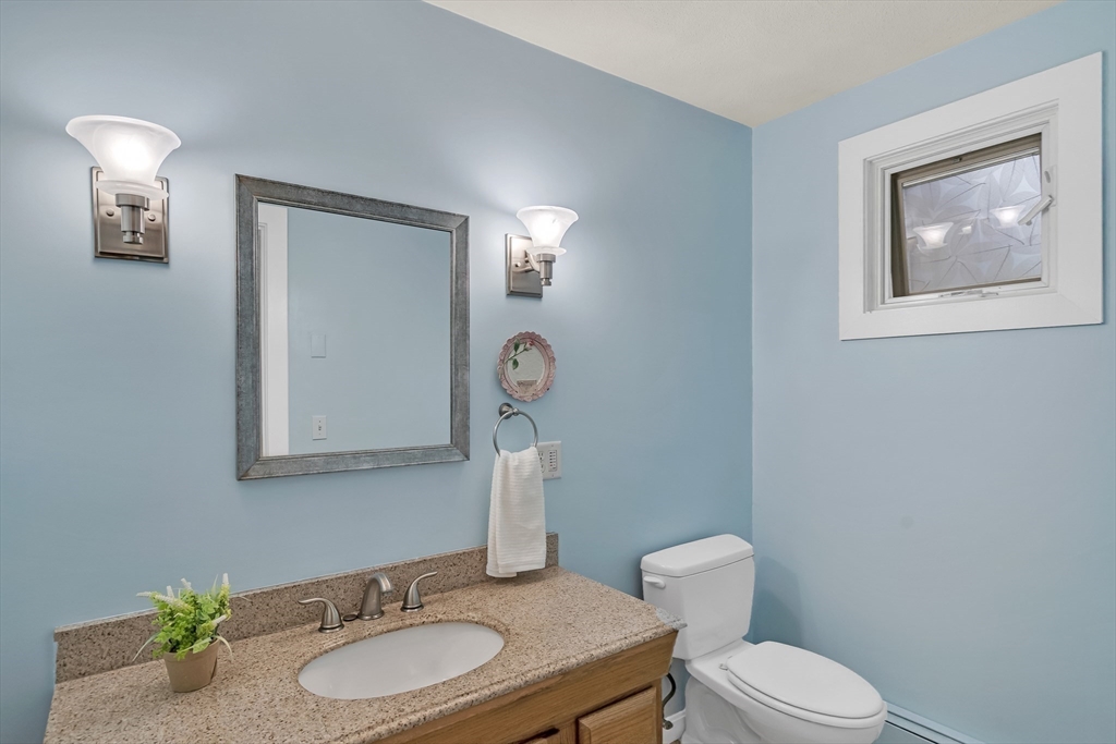 71 Grassland Street Lexington, MA 02421 - Photo 20 of 38 a bathroom with a granite countertop toilet a sink and mirror