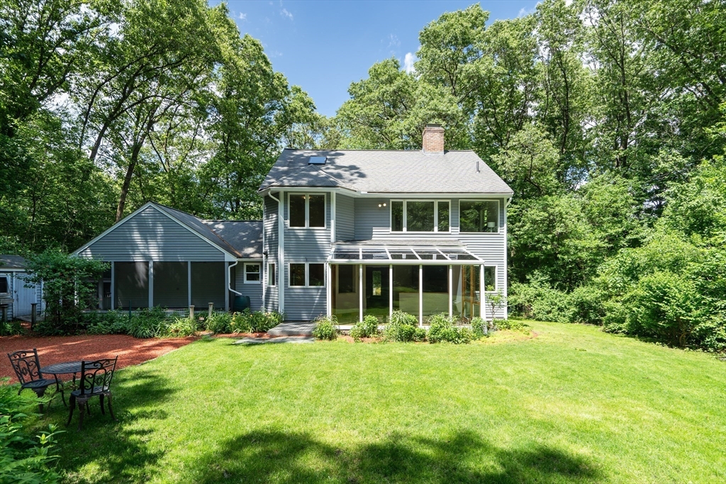 71 Grassland Street Lexington, MA 02421 - Photo 3 of 38 a front view of a house with a yard table and chairs