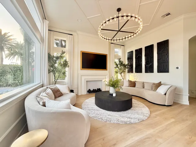 a living room with furniture a flat screen tv and a large window