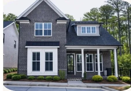 a brick house that has a small yard and large trees