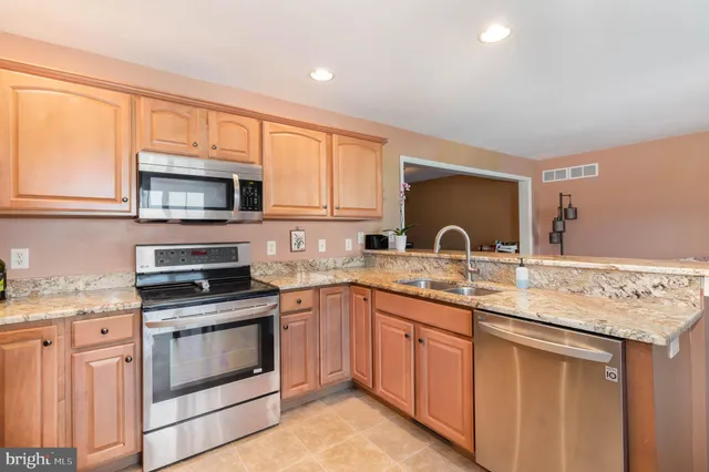 a kitchen with stainless steel appliances granite countertop a stove microwave and sink