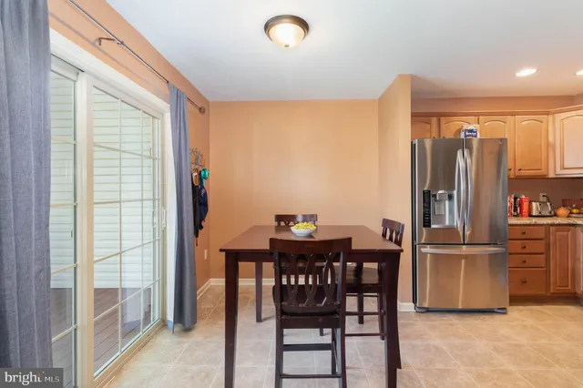 a kitchen with stainless steel appliances a refrigerator a stove a dining table and chairs