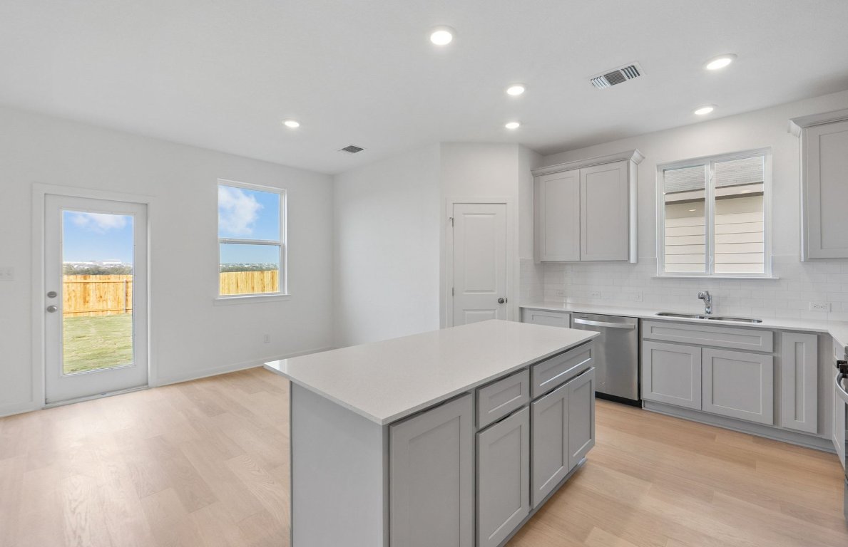 400 Sullivan Way Elgin, TX 78621 - Photo 9 of 30 a kitchen with a sink stove and cabinets