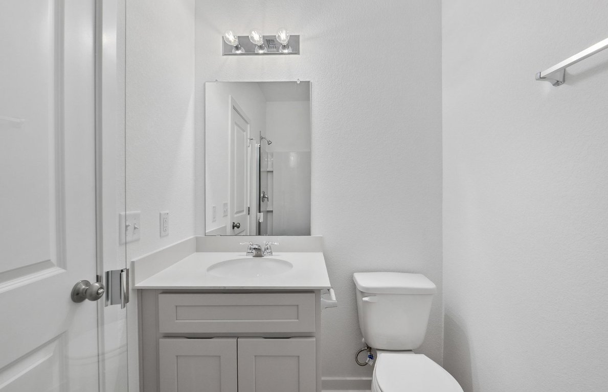 400 Sullivan Way Elgin, TX 78621 - Photo 21 of 30 a bathroom with a toilet sink and mirror