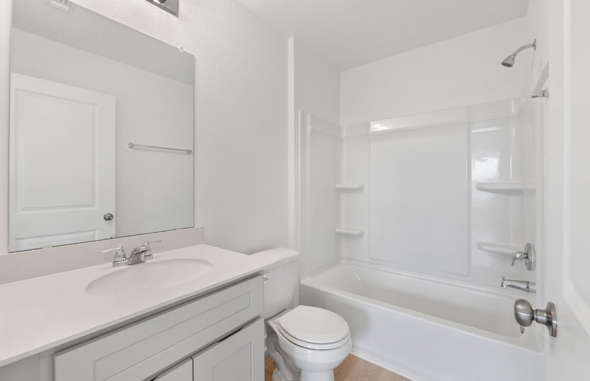 400 Sullivan Way Elgin, TX 78621 - Photo 25 of 30 a bathroom with a granite countertop sink a toilet and bathtub