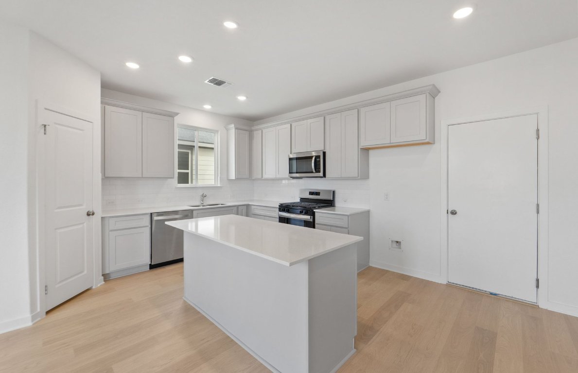 400 Sullivan Way Elgin, TX 78621 - Photo 8 of 30 a kitchen with a sink a counter top space stainless steel appliances and cabinets