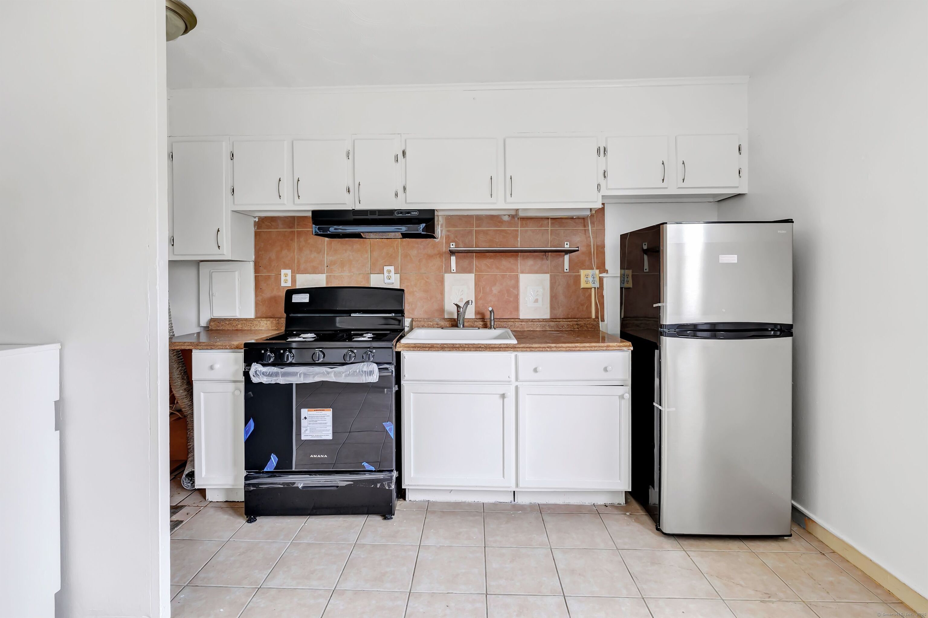 367 D Building 5 Granfield Avenue Bridgeport, CT 06610 - Photo 5 of 13 a kitchen with cabinets and stainless steel appliances
