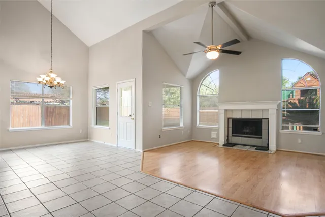 an empty room with windows and fireplace