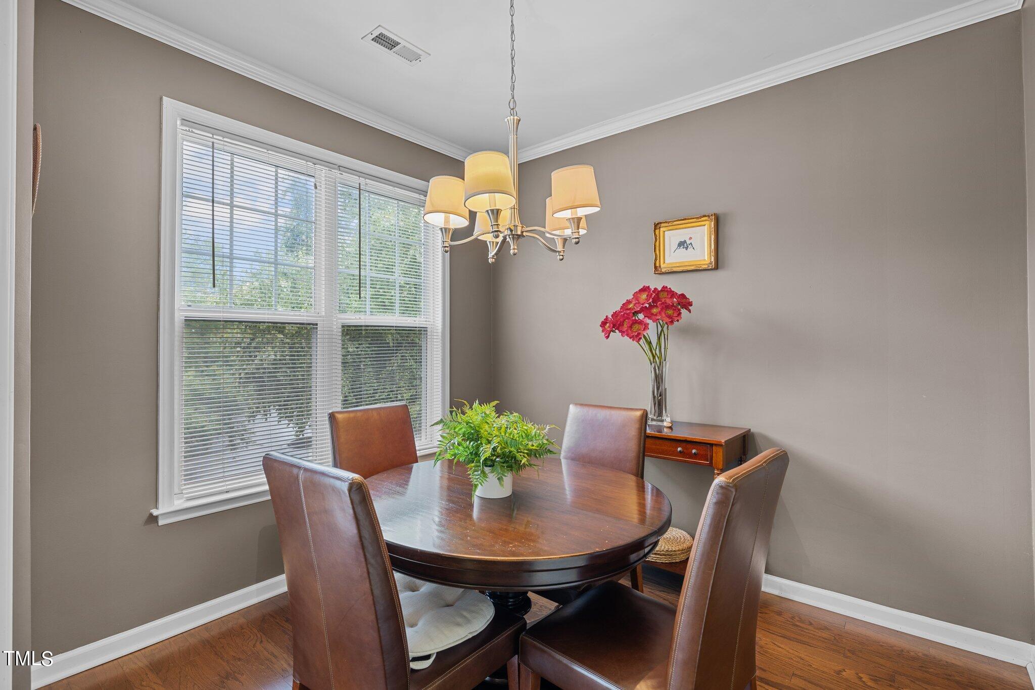1710 Tiffany Bay Court, Unit 301 Raleigh, NC 27609 - Photo 8 of 36 a dining room with furniture potted plants and wooden floor