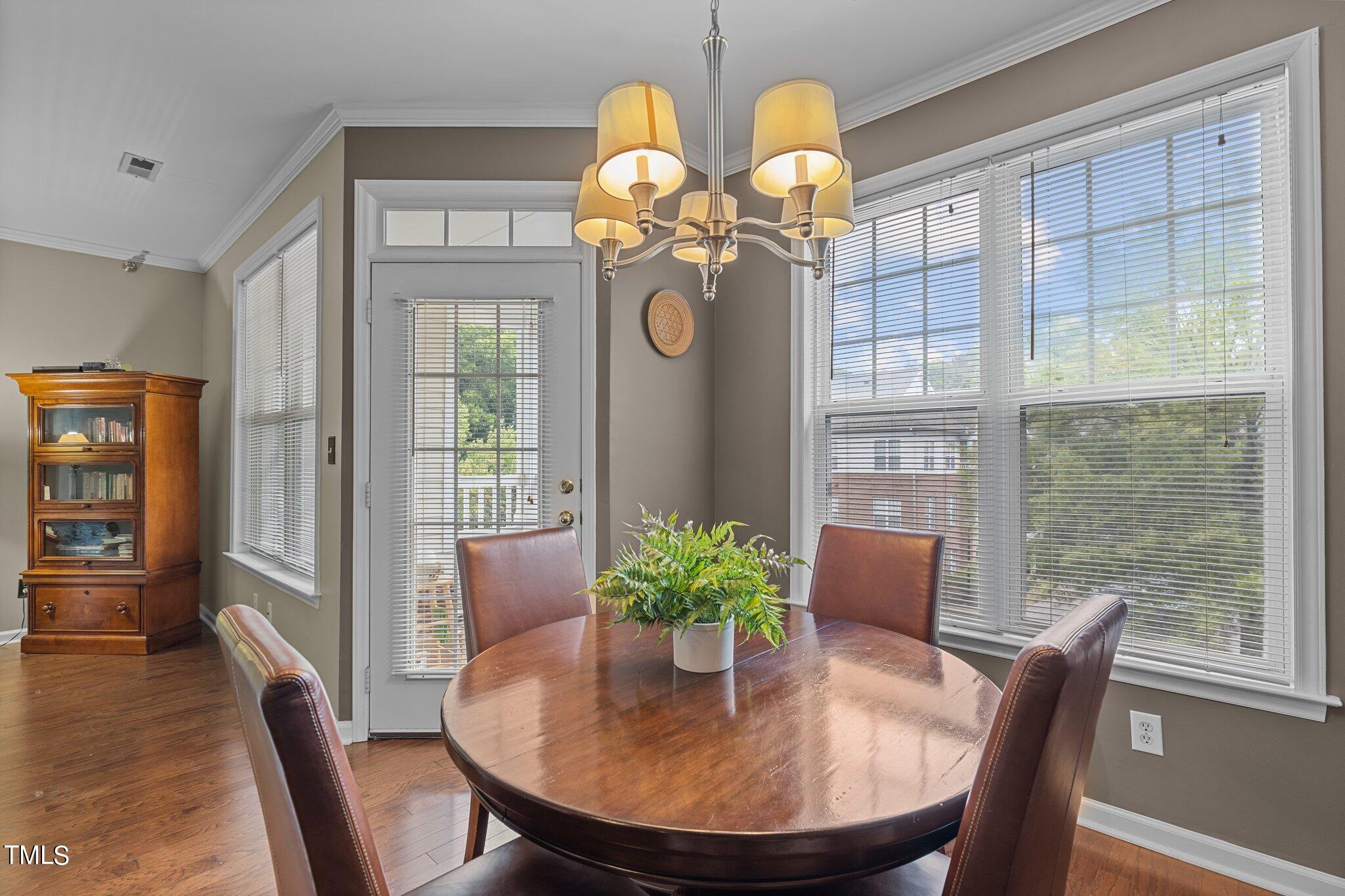 1710 Tiffany Bay Court, Unit 301 Raleigh, NC 27609 - Photo 9 of 36 a dining room with furniture potted plants and wooden floor