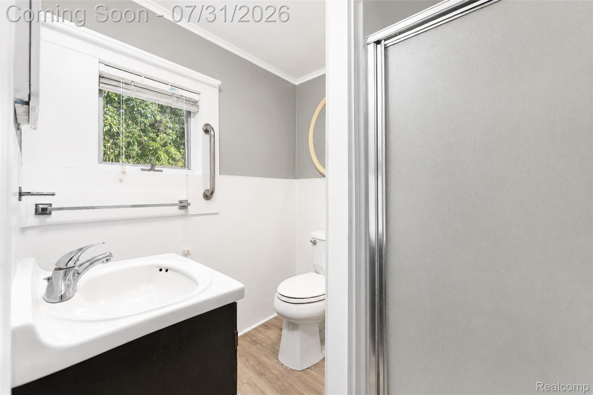 5269 Reno Road Manchester, MI 48158 - Photo 59 of 64 Bathroom featuring a pedestal sink with a chrome faucet, wood-finish flooring, a toilet, a frosted glass shower enclosure, and a window with blinds