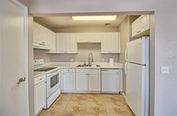a kitchen with white cabinets and white appliances