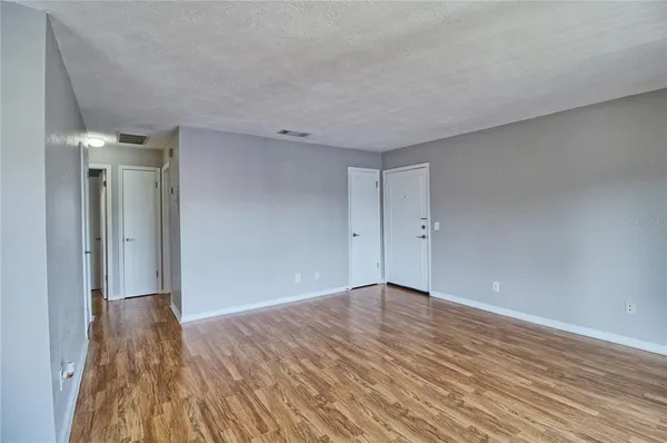 a view of an empty room with wooden floor