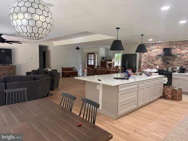 a living room with furniture a chandelier and kitchen view