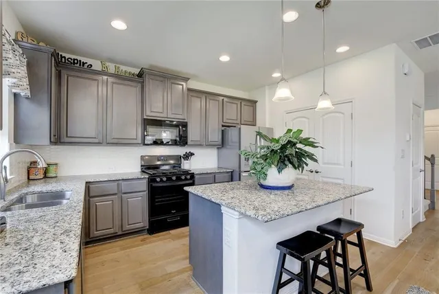 a kitchen with granite countertop stainless steel appliances and wooden cabinets