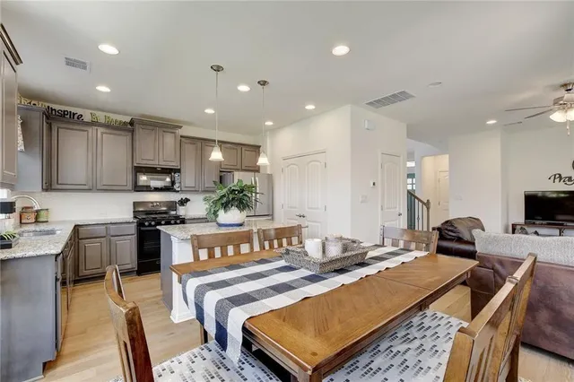 a living room with stainless steel appliances kitchen island granite countertop a stove a sink a refrigerator and a refrigerator