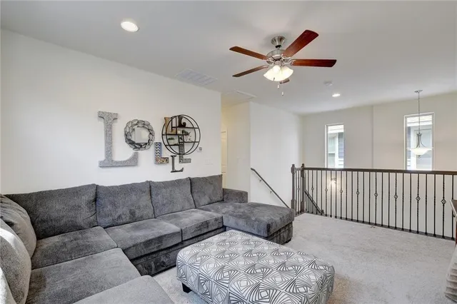 a living room with furniture with a ceiling fan and a ceiling fan