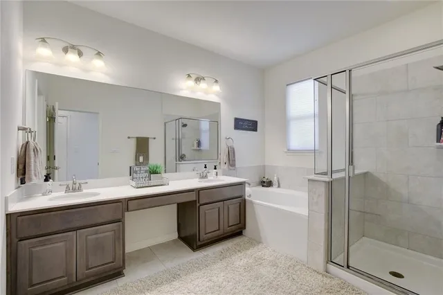 a spacious bathroom with a bathtub shower sink double and mirror