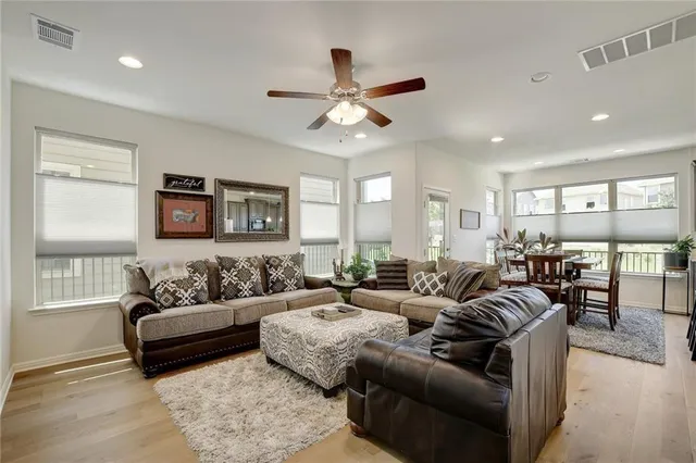 a living room with furniture ceiling fan and a window
