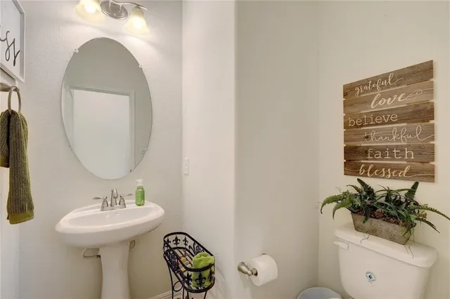 a bathroom with a sink a toilet and a mirror
