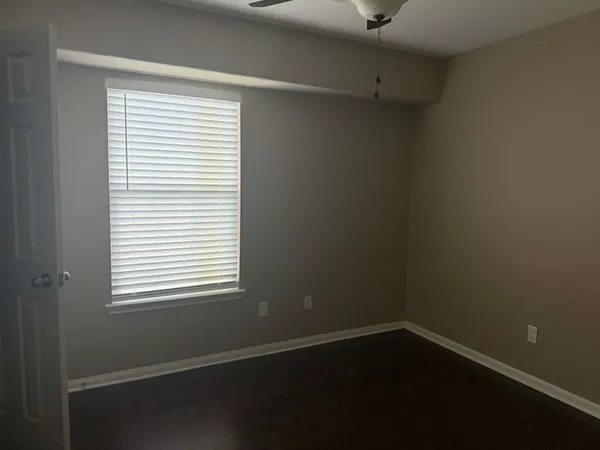 a view of a small space with wooden floor and a window