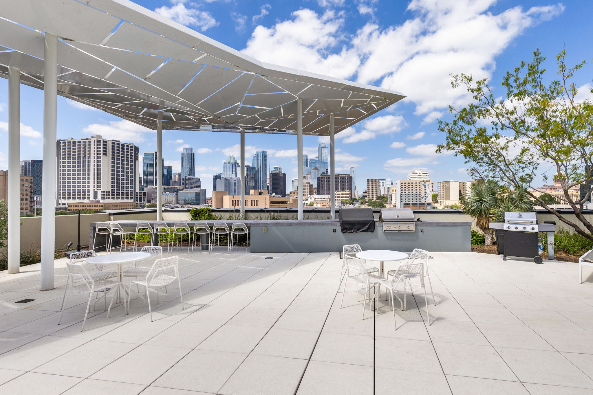 800 Embassy Drive, Unit 113 Austin, TX 78702 - Photo 24 of 36 View of patio / terrace with outdoor dining space, a skyline view, and a grill