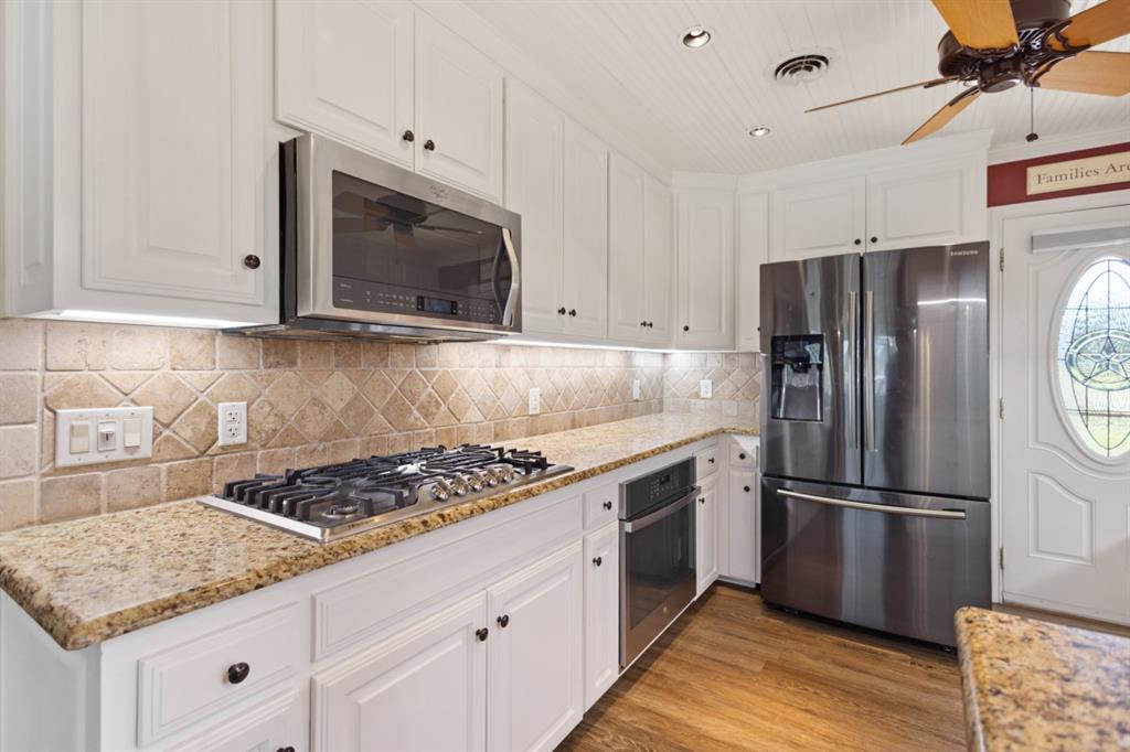 227 Scenic Road Trinidad, TX 75163 - Photo 8 of 40 a kitchen with granite countertop a sink stove and refrigerator