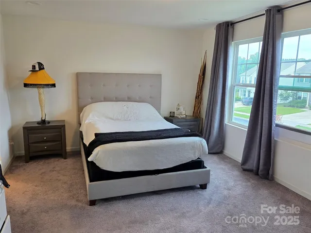 a bed sitting in a bedroom next to a window