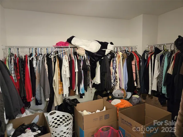 a view of walk in closet with clothes