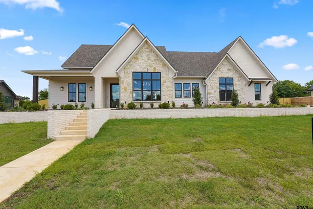a front view of a house with a yard and trees