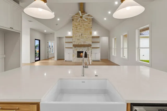 a large kitchen with a sink and chandelier