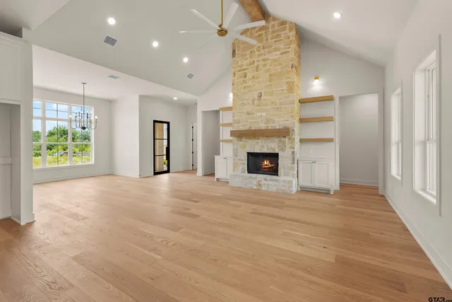 a view of an empty room with a fireplace and a window