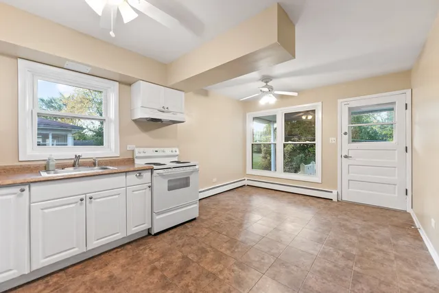 a kitchen with a refrigerator sink and cabinets