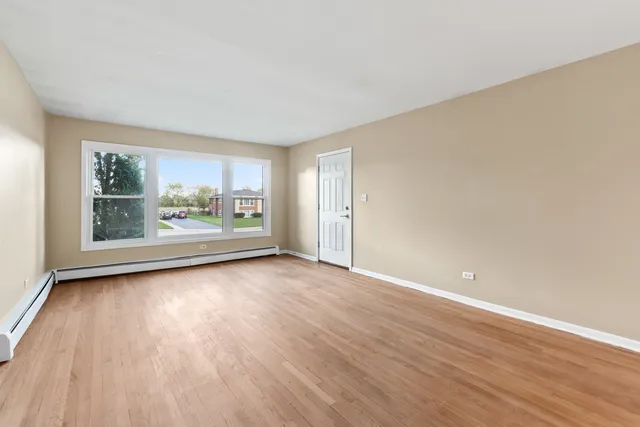 a view of a room with wooden floor and window