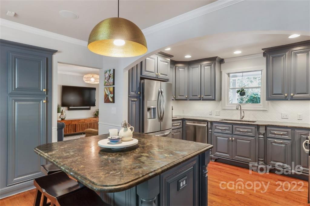 1023 Sedgefield Road Charlotte, NC 28209 - Photo 1 of 40 a kitchen with stainless steel appliances granite countertop a sink a stove a dining table and chairs