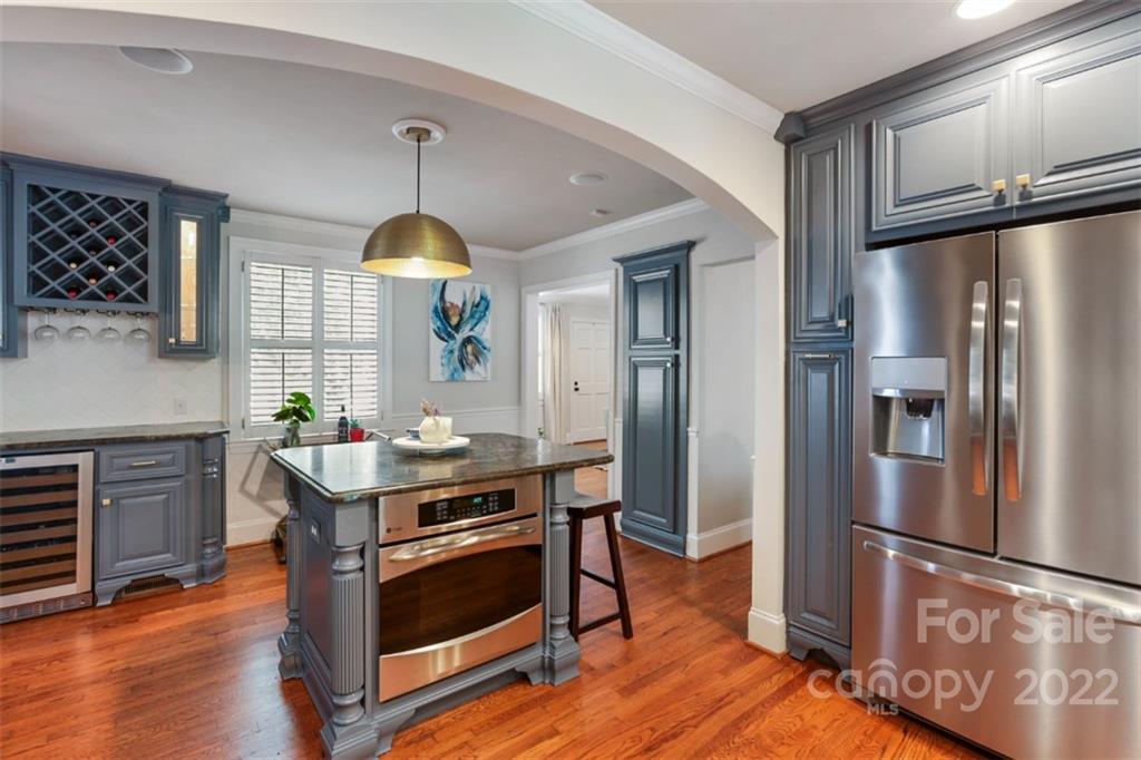 1023 Sedgefield Road Charlotte, NC 28209 - Photo 11 of 40 a kitchen with stainless steel appliances granite countertop a refrigerator a stove and a wooden floors