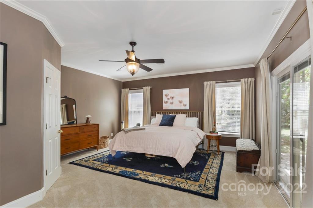 1023 Sedgefield Road Charlotte, NC 28209 - Photo 18 of 40 a bedroom with a bed and glass walk in closet