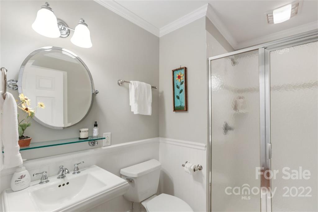 1023 Sedgefield Road Charlotte, NC 28209 - Photo 24 of 40 a bathroom with a toilet a sink and a mirror