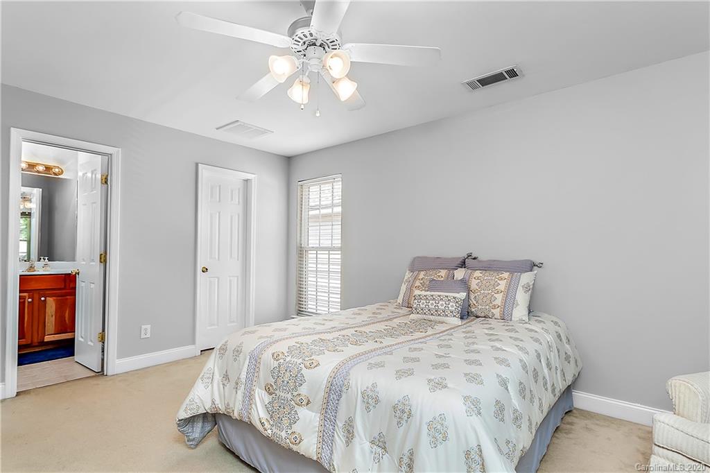 13011 Meadowmere Road Huntersville, NC 28078 - Photo 17 of 20 a bedroom with a large bed and a chandelier